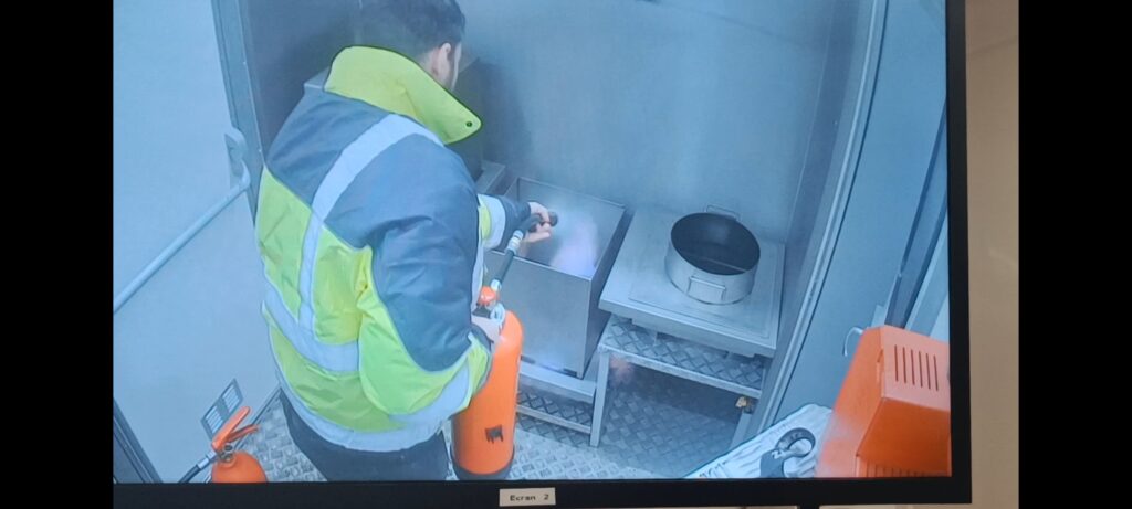 Un de nos collaborateurs pendant la formation incendie en train de tester un extincteur sur des flammes